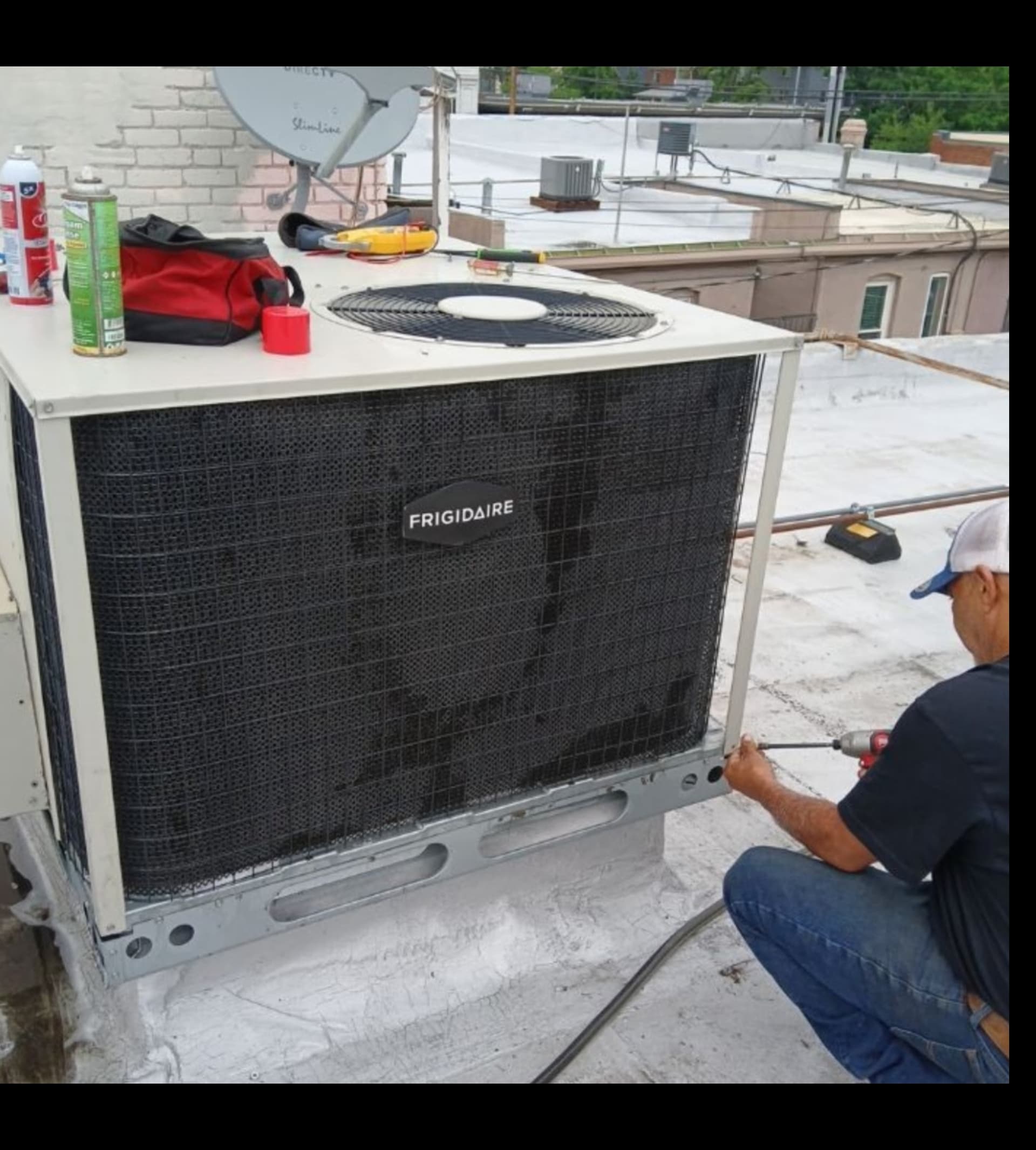 HVAC technician servicing commercial Frigidaire rooftop unit in Denver